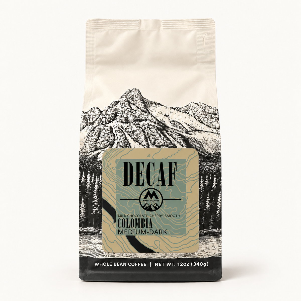 A 12 oz bag of Decaf Colombia Medium-Dark whole bean coffee, featuring a cream-colored background with a black line-art mountain illustration and a central beige label.