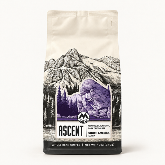 A 12 oz bag of Ascent Coffee's South America Dark coffee, featuring a cream-colored background with a black and white mountain illustration and a purple accent graphic.